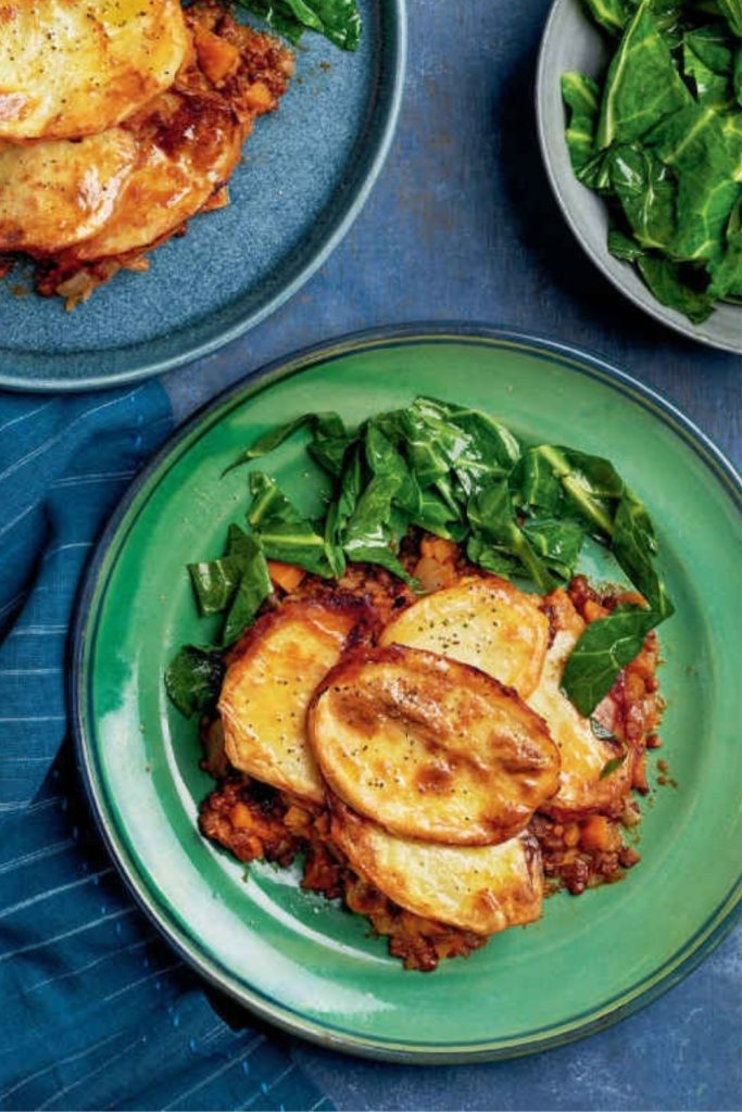 Slow Cooker Lancashire Hot Pot on a green plate with greens on the side.
