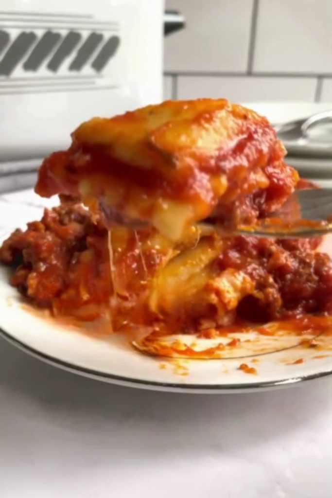 A slice of Slow Cooker Ravioli Lasagna on a white plate.