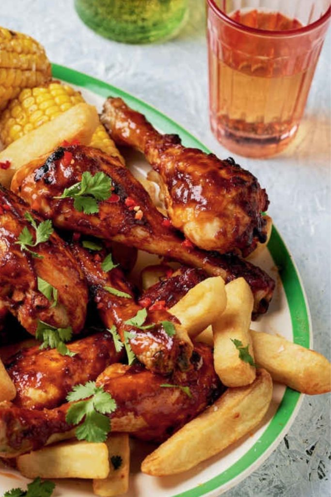 Slow Cooker Spicy Chicken Drumsticks with fries and corn.
