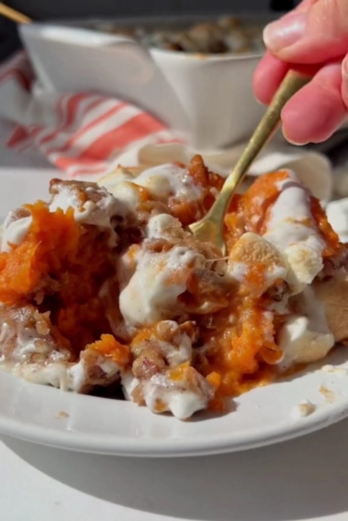 a spoonful of Sweet Potato Casserole with marshmallows and pecans.