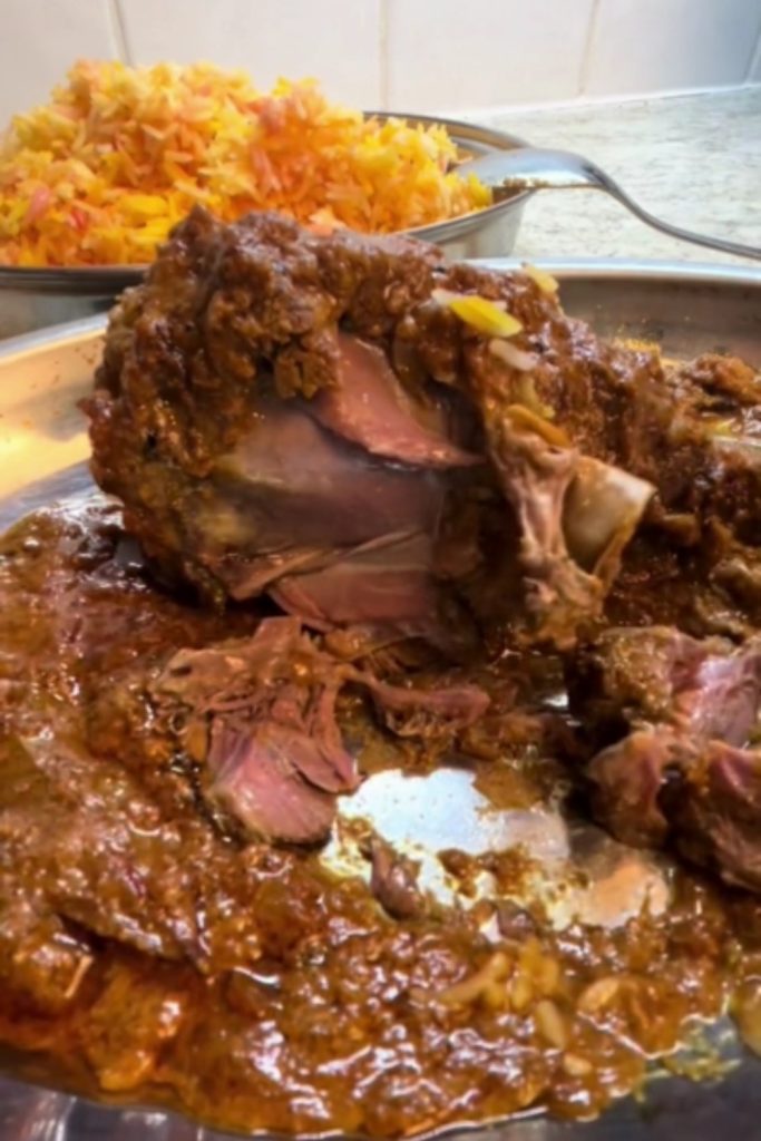 Slow Cooker Lamb Shank Rogan Josh with the meat falling off the bone, served with saffron rice.