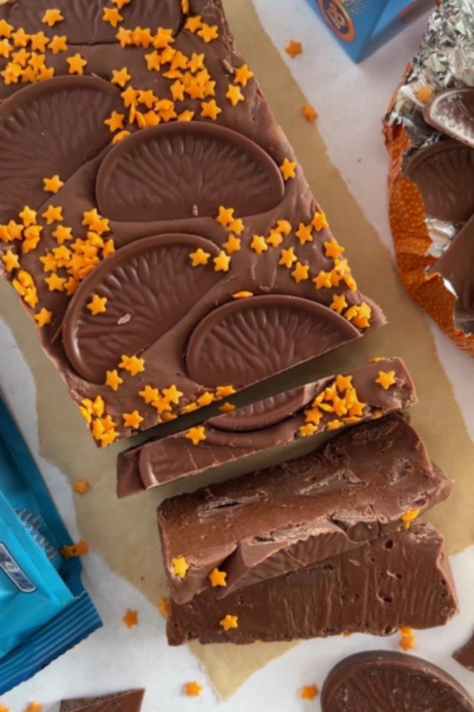 Slow Cooker Chocolate Orange Fudge topped with orange chocolate slices and star sprinkles.