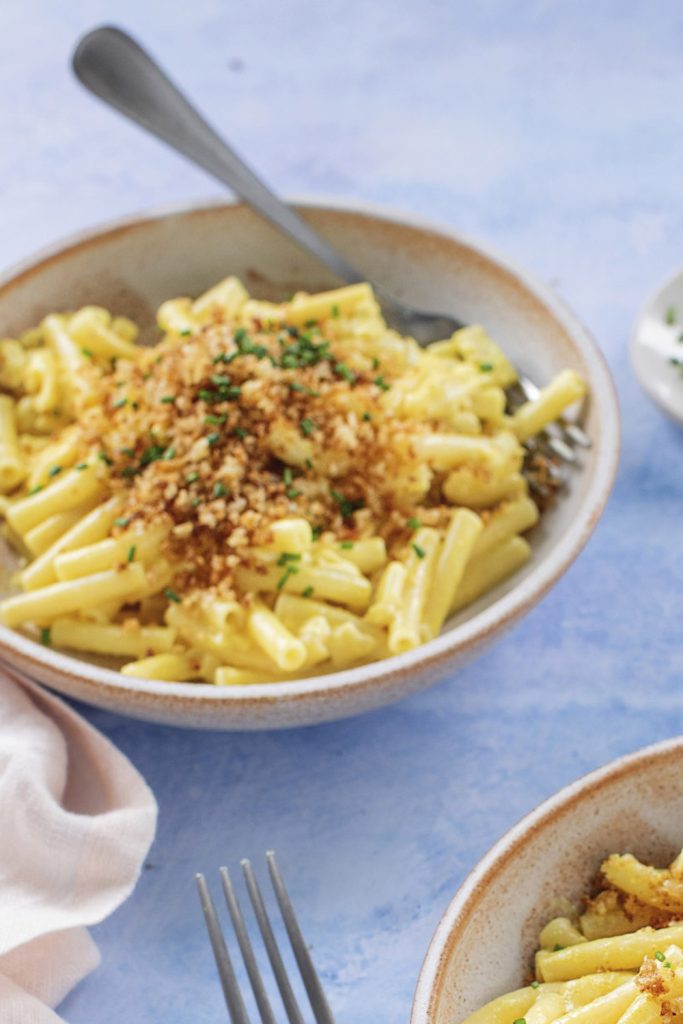 garlic mac and cheese with breadcrumbs and chives in a bowl.