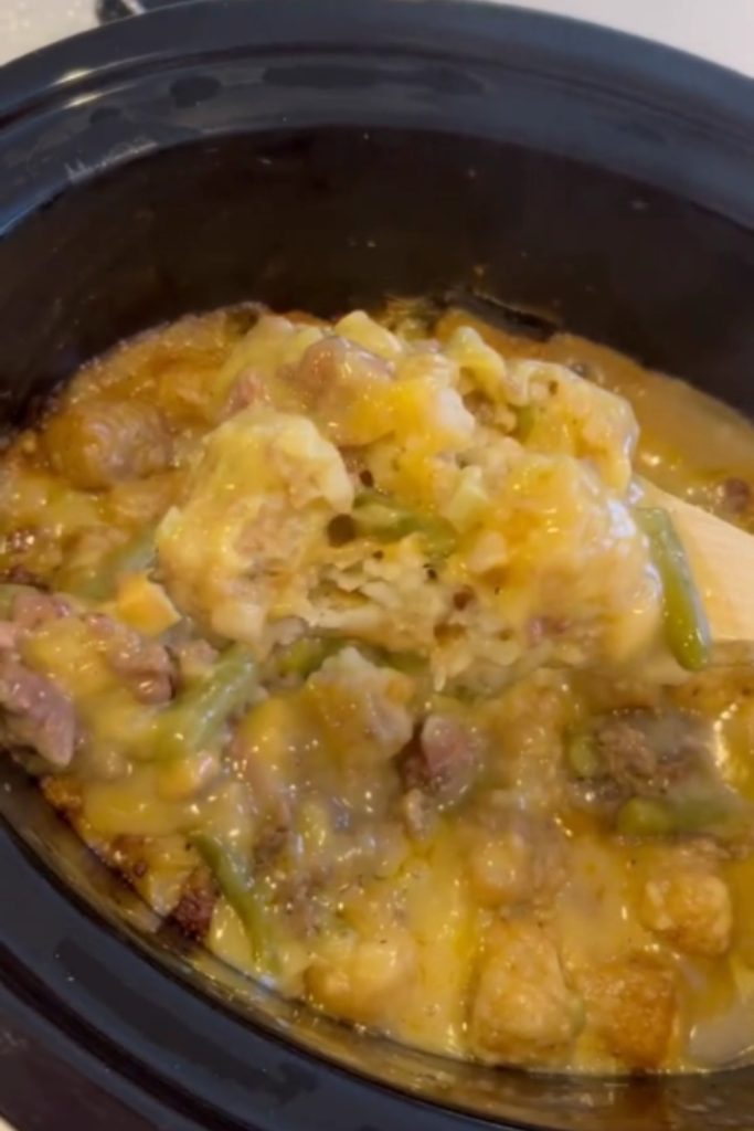  Slow Cooker Tater Tot Casserole with melted cheese, green beans, and ground beef in a crockpot.