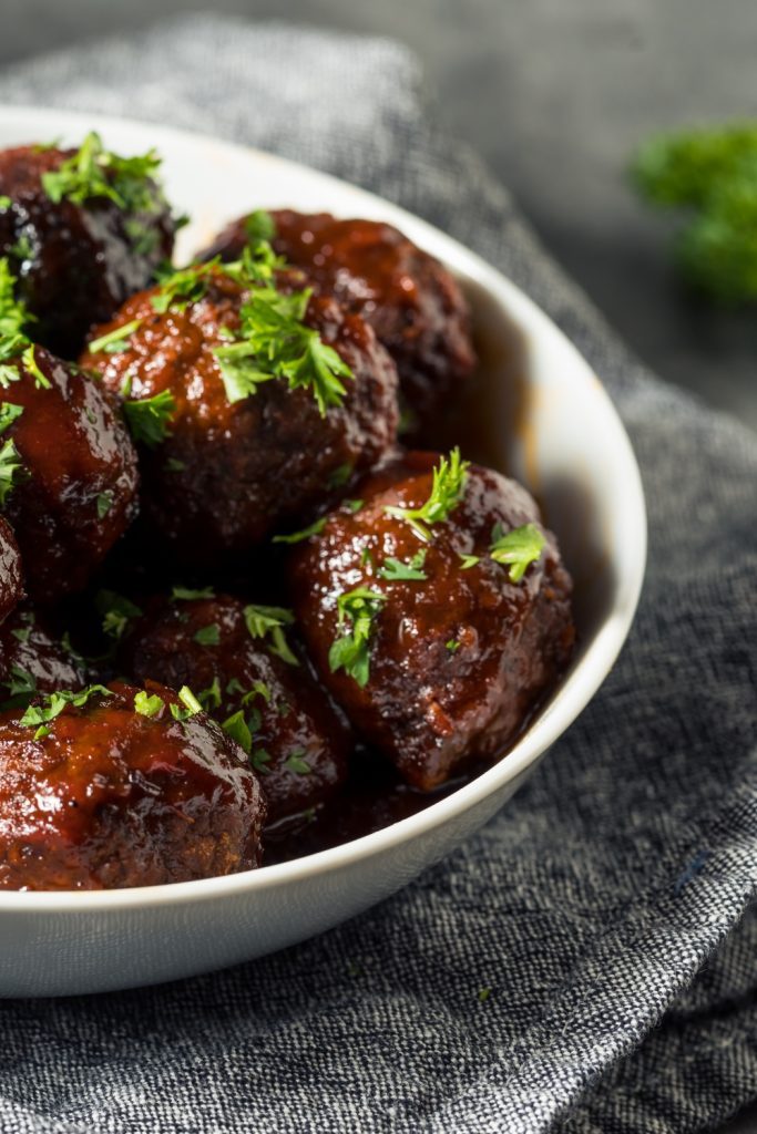 crockpot meatballs with sauce and parsley on top.