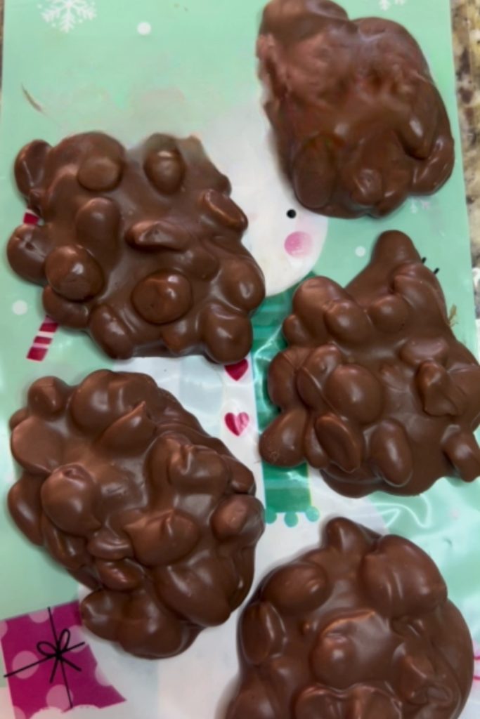 Chocolate peanut clusters on festive wrapping paper.