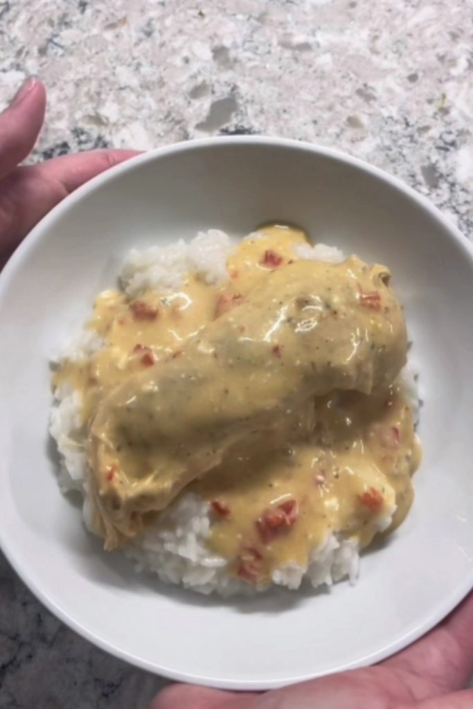 Crockpot ranch chicken served over white rice in a white bowl.