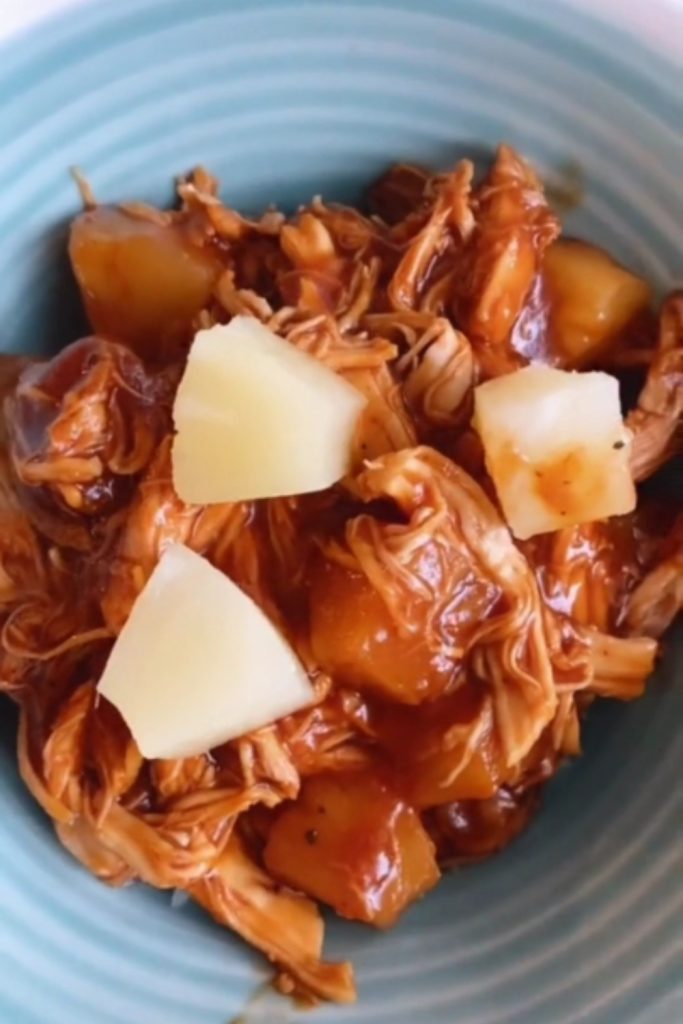 Hawaiian Chicken with pineapple chunks in a blue bowl.