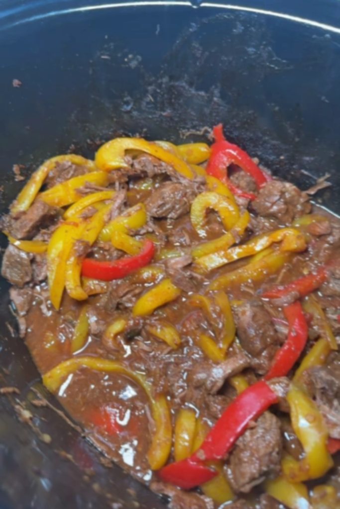 Slow-cooked steak fajitas with red and yellow bell peppers.