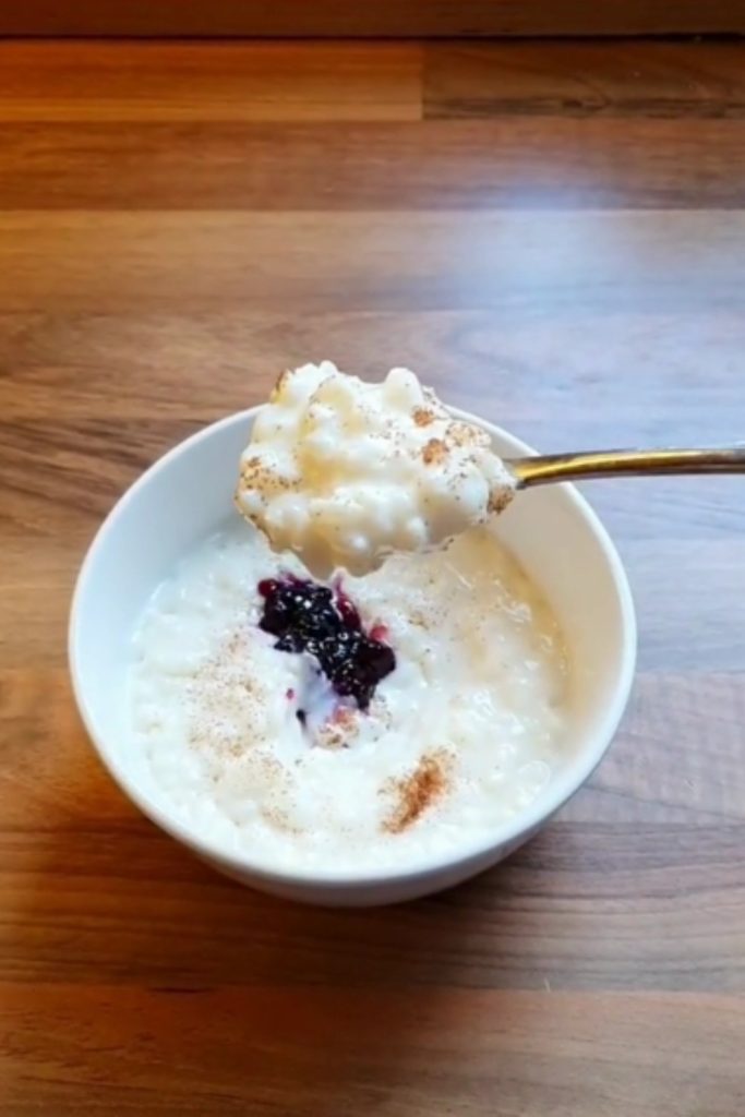 Slow Cooker Almond Milk Rice Pudding in a bowl, topped with cinnamon and berry compote.