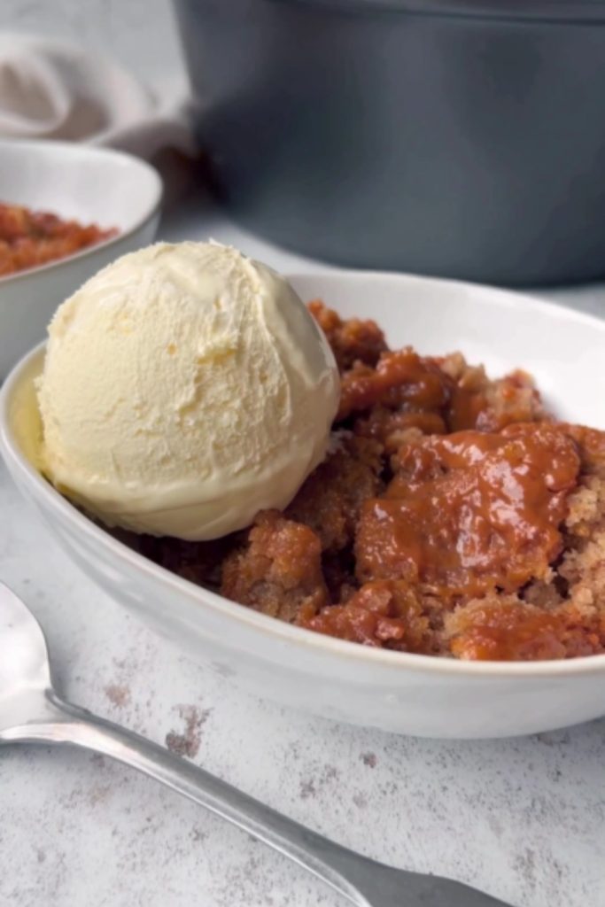 Slow Cooker Banana Bread Pudding with vanilla ice cream in a white bowl.