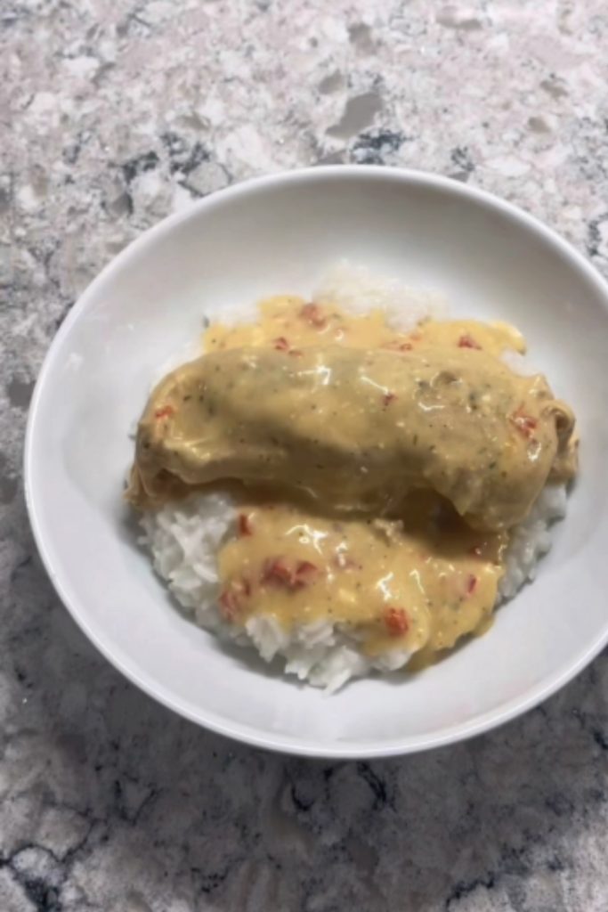 Crockpot ranch chicken served over white rice in a white bowl.