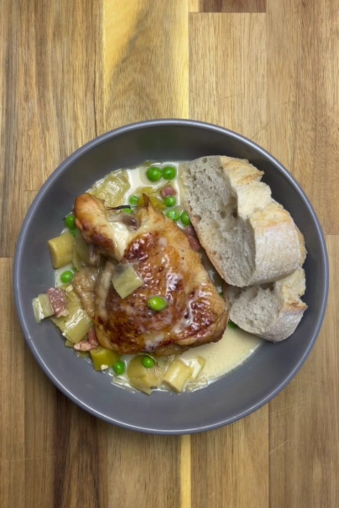 Slow Cooker Honey Mustard Chicken served with green peas and crusty bread.