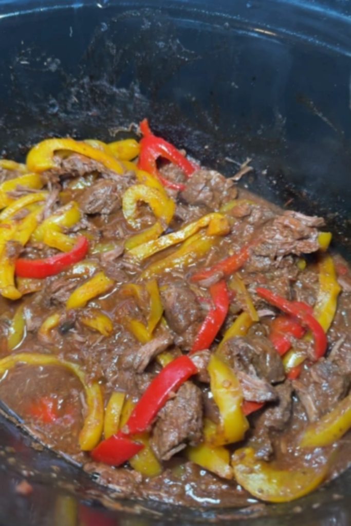 Slow-cooked steak fajitas with red and yellow bell peppers.