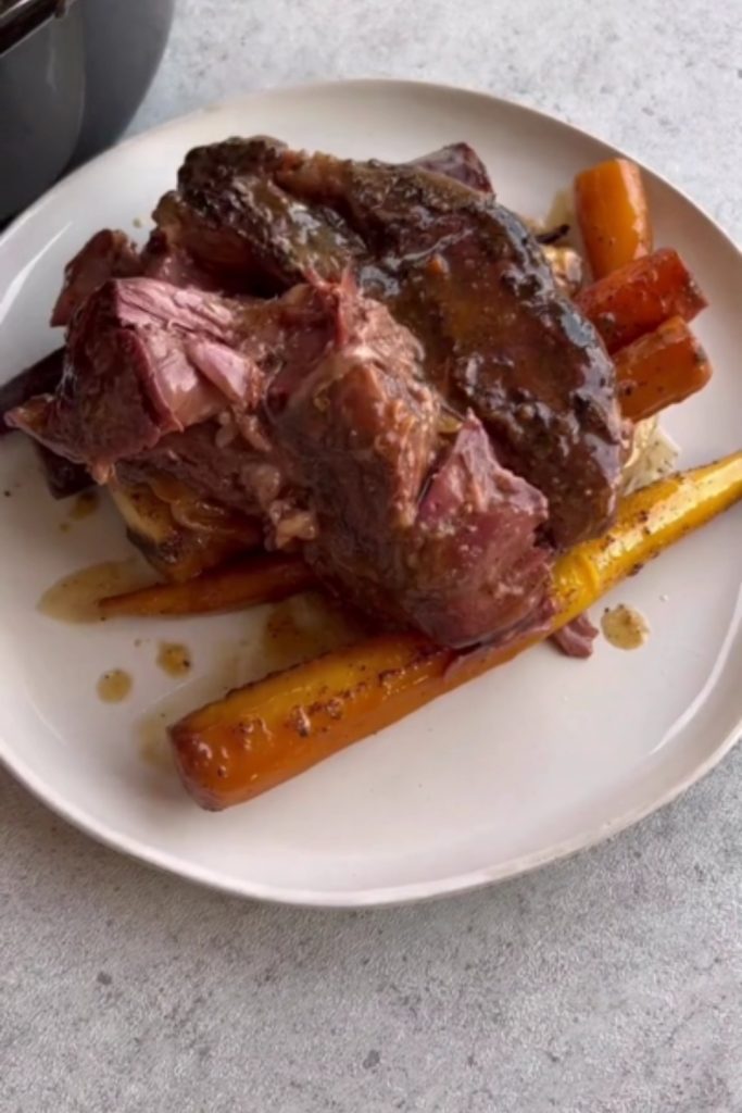 pot roast with carrots and parsley in a rich sauce.