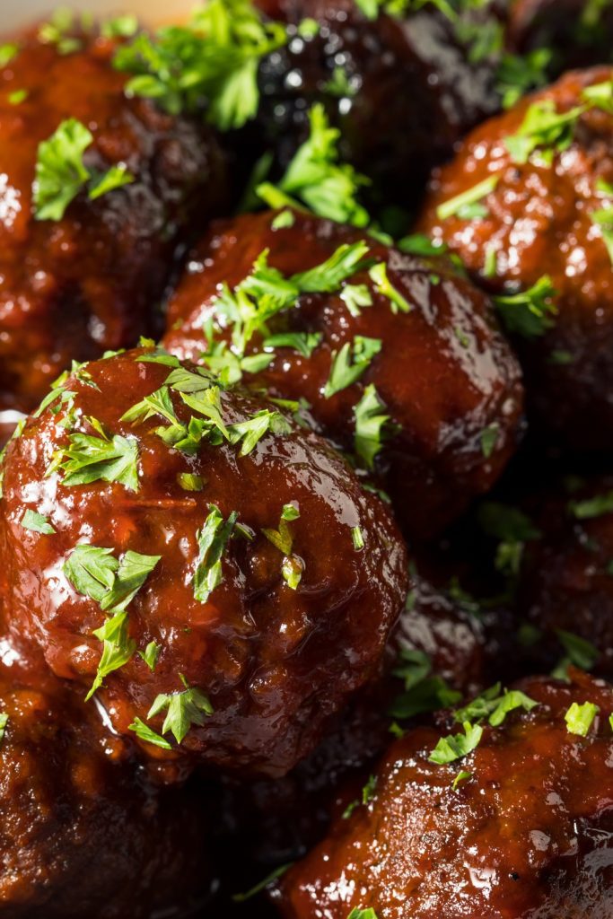 rockpot meatballs in a white bowl, garnished with parsley.