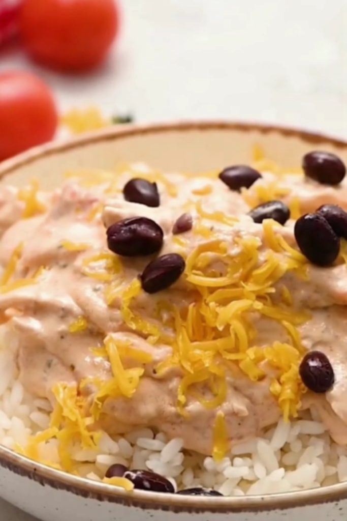 Slow Cooker Salsa Chicken on rice with black beans, cheese, and green onions.